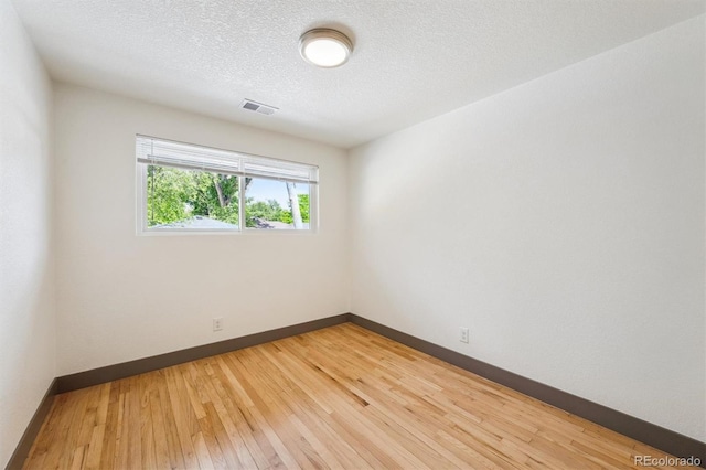 1112-11121/2 Krameria St, Denver, CO 80220 - empty room featuring light wood-type flooring and a textured ceiling