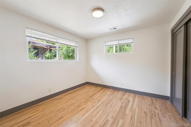 1112-11121/2 Krameria St, Denver, CO 80220 - unfurnished room featuring light wood-style floors and a textured ceiling