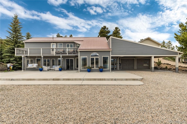 369 County Road 4051, Granby, CO 80446 - rear view of house featuring metal roof, a garage, a balcony, and driveway