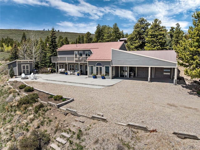 369 County Road 4051, Granby, CO 80446 - rear view of property with a garage, metal roof, driveway, and a balcony