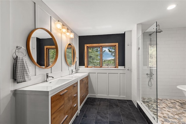 369 County Road 4051, Granby, CO 80446 - full bathroom with tiled shower, double vanity, a decorative wall, and a wainscoted wall
