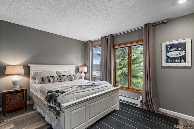 369 County Road 4051, Granby, CO 80446 - bedroom with baseboard heating, a textured ceiling, and dark wood-type flooring