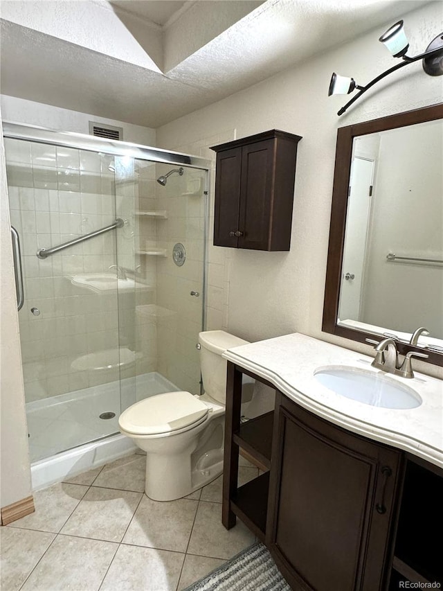 bathroom with vanity, a textured ceiling, tile patterned flooring, toilet, and an enclosed shower