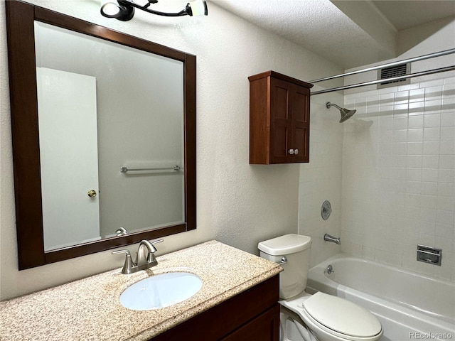 full bathroom featuring tiled shower / bath, vanity, toilet, and a textured ceiling