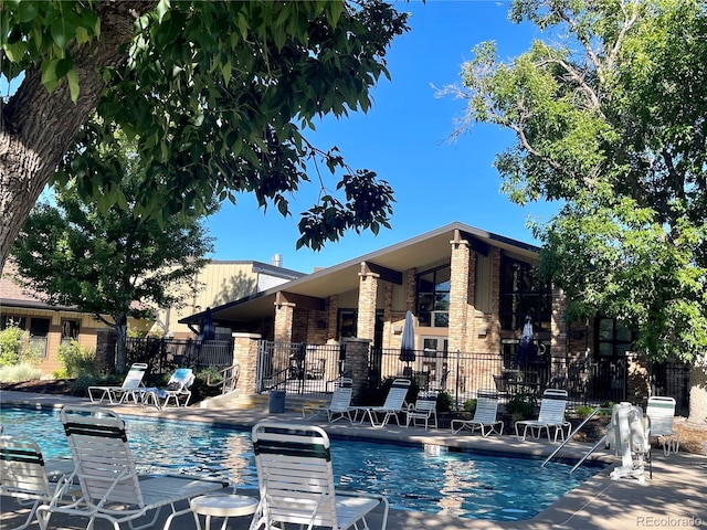 community pool with fence and a patio