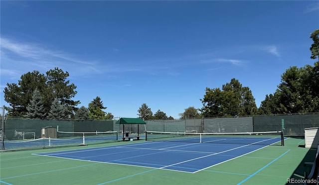 view of tennis court featuring fence