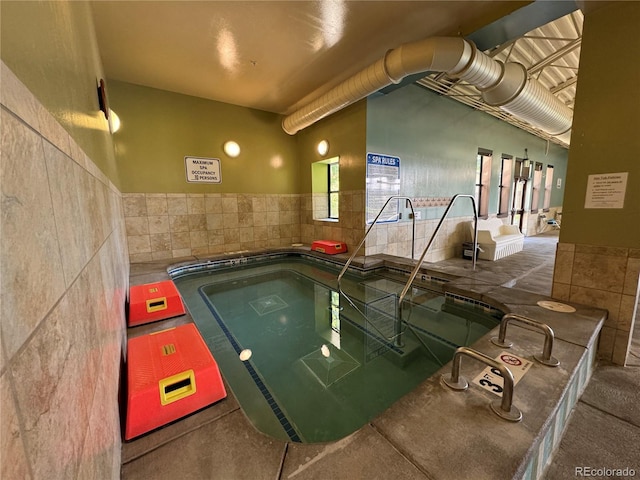 view of swimming pool featuring an indoor hot tub