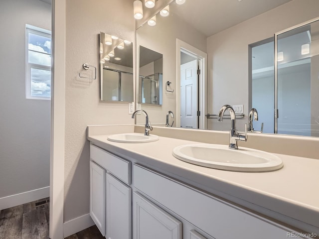 4773 Kittredge St, Denver, CO 80239 - bathroom with wood finished floors, baseboards, double vanity, and an enclosed shower
