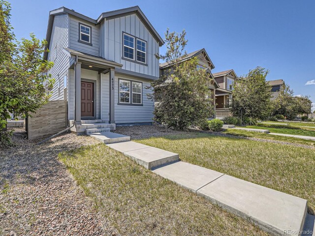 4773 Kittredge St, Denver, CO 80239 - view of front facade featuring board and batten siding and a front lawn