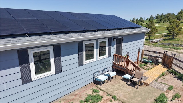40291 Gold Nugget Dr, Deer Trail, CO 80105 - back of property featuring a shingled roof, roof mounted solar panels, and a patio