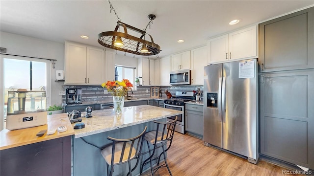 40291 Gold Nugget Dr, Deer Trail, CO 80105 - kitchen featuring stainless steel appliances, light stone counters, a breakfast bar, recessed lighting, and backsplash