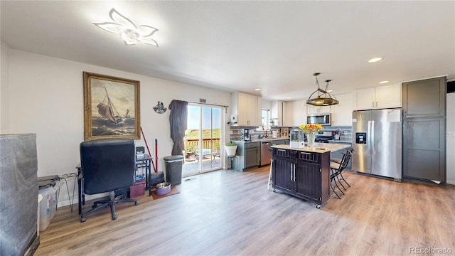 40291 Gold Nugget Dr, Deer Trail, CO 80105 - kitchen with stainless steel appliances, light wood-style floors, a breakfast bar area, light countertops, and recessed lighting