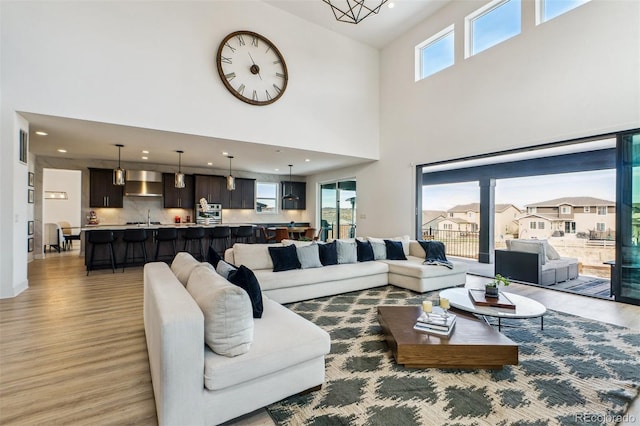 living room featuring light wood-style flooring, recessed lighting, and a wealth of natural light