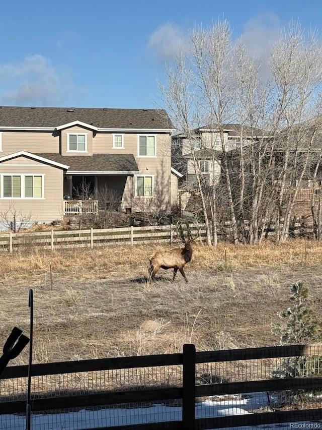 view of front of property with fence and a shingled roof