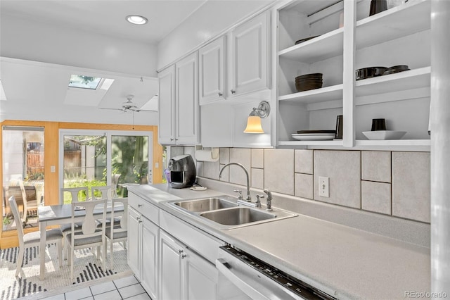 1732 Lansing St, Aurora, CO 80010 - kitchen featuring a skylight, white cabinets, light tile patterned floors, light countertops, and recessed lighting