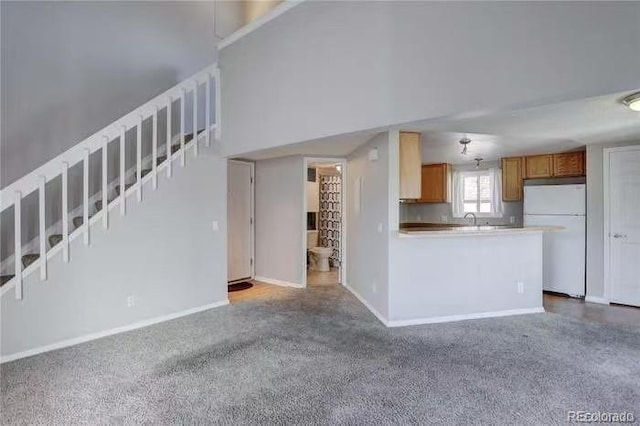 unfurnished living room with stairway and baseboards