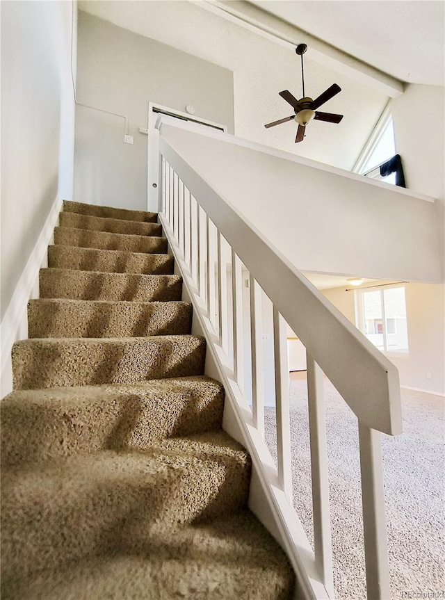 staircase with beam ceiling, a ceiling fan, and high vaulted ceiling