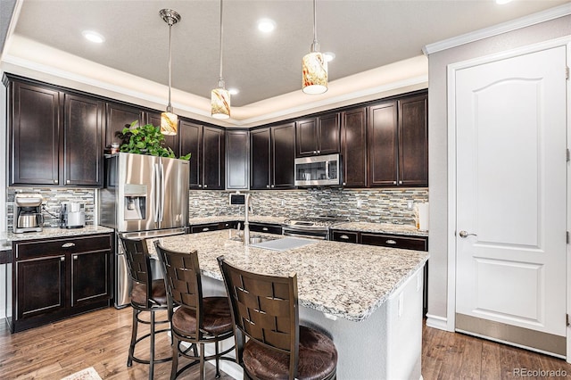 13326 Olive Way, Thornton, CO 80602 - kitchen with appliances with stainless steel finishes, light wood-style floors, light stone countertops, tasteful backsplash, and pendant lighting