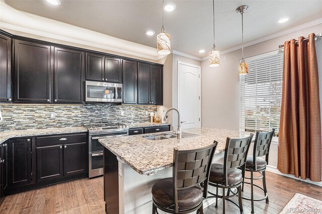 13326 Olive Way, Thornton, CO 80602 - kitchen featuring stainless steel appliances, crown molding, light wood-style floors, backsplash, and light stone counters