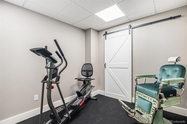 13326 Olive Way, Thornton, CO 80602 - workout room with a barn door, a paneled ceiling, and baseboards