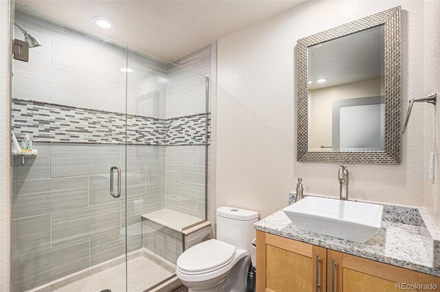 13326 Olive Way, Thornton, CO 80602 - full bath with toilet, vanity, a shower stall, and a textured wall