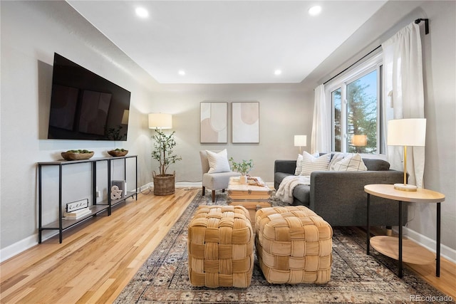 living room featuring baseboards, wood finished floors, and recessed lighting