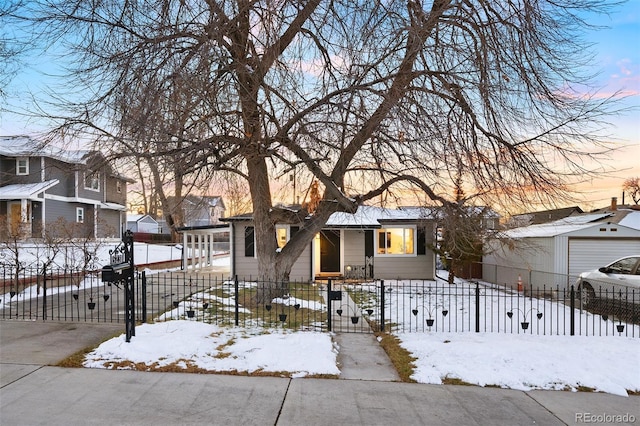 view of front of home featuring driveway, a fenced front yard, and a gate