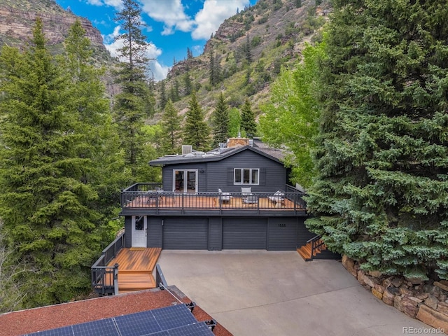 view of property featuring a garage and a wooden deck