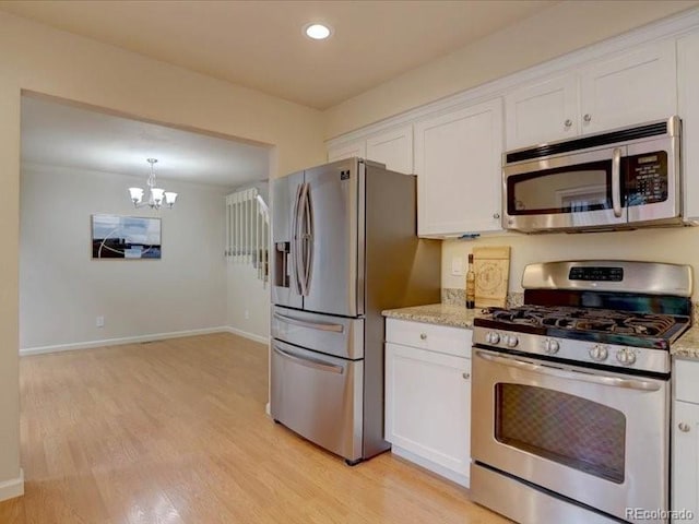 11867 Elk Head Range Rd, Littleton, CO 80127 - kitchen with stainless steel appliances, white cabinetry, light wood-style flooring, a chandelier, and light stone countertops