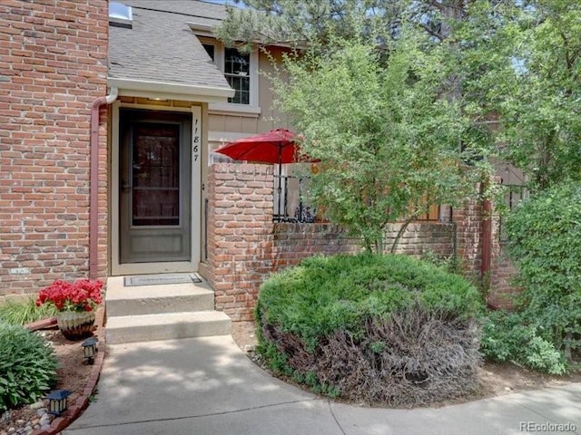 11867 Elk Head Range Rd, Littleton, CO 80127 - doorway to property with brick siding and roof with shingles