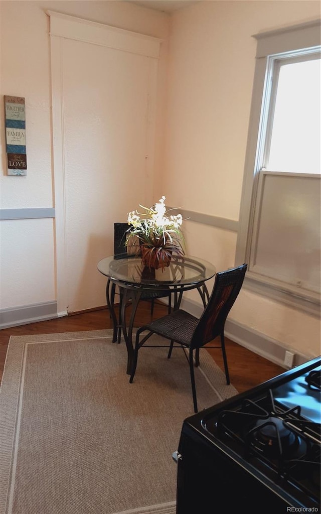 dining area with baseboards and wood finished floors