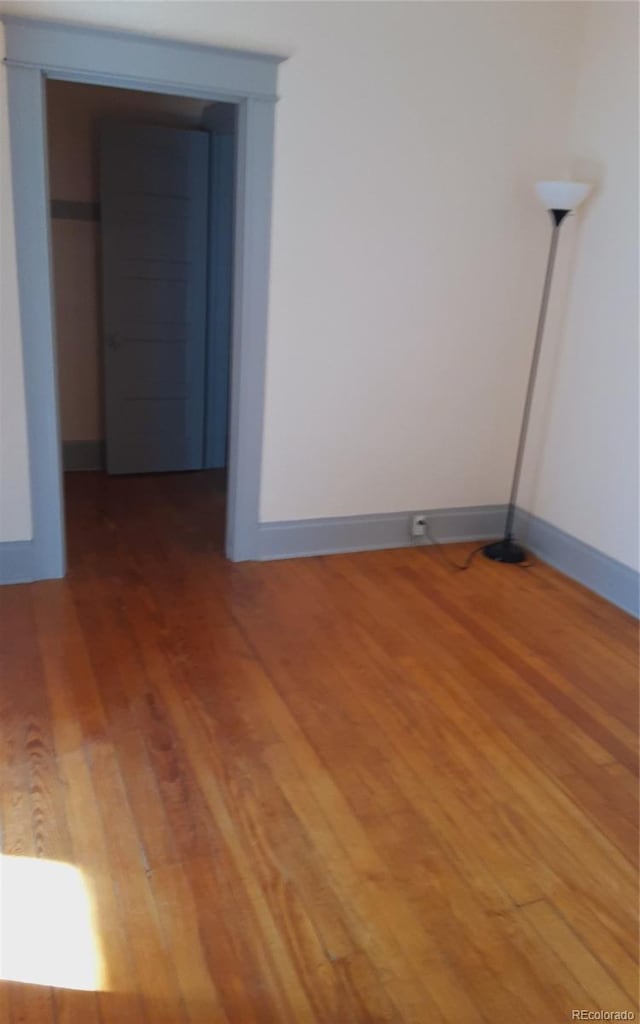 unfurnished room featuring baseboards and light wood finished floors