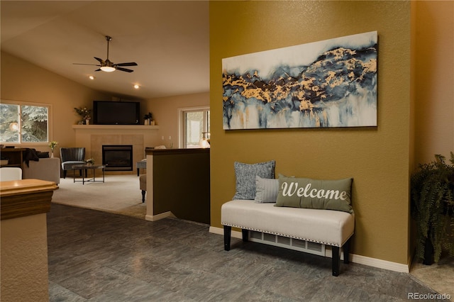 sitting room with plenty of natural light, a fireplace, ceiling fan, and vaulted ceiling