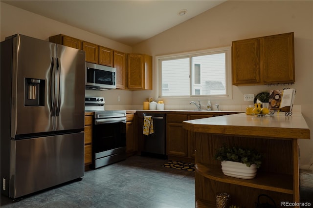 kitchen featuring lofted ceiling, dark tile patterned flooring, kitchen peninsula, and stainless steel appliances