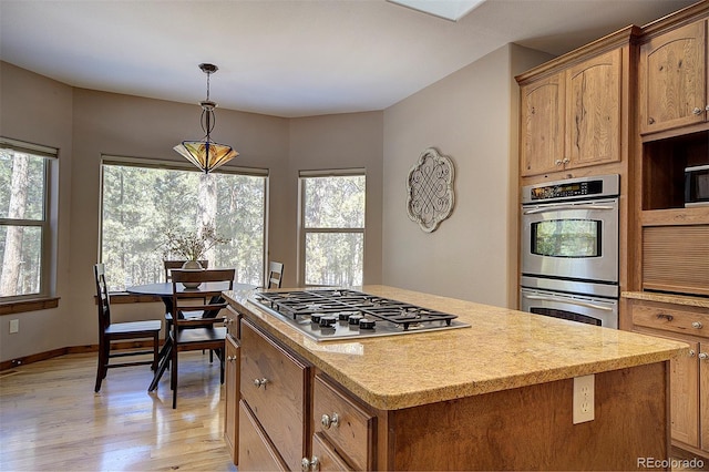 kitchen with plenty of natural light, a center island, light wood-type flooring, and stainless steel appliances