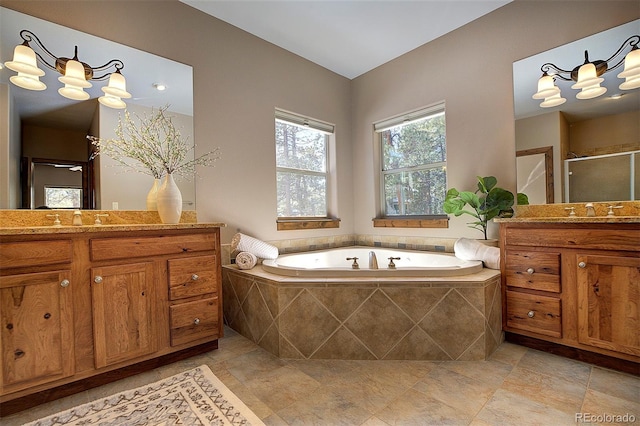 full bathroom with a bath, a sink, a stall shower, and two vanities