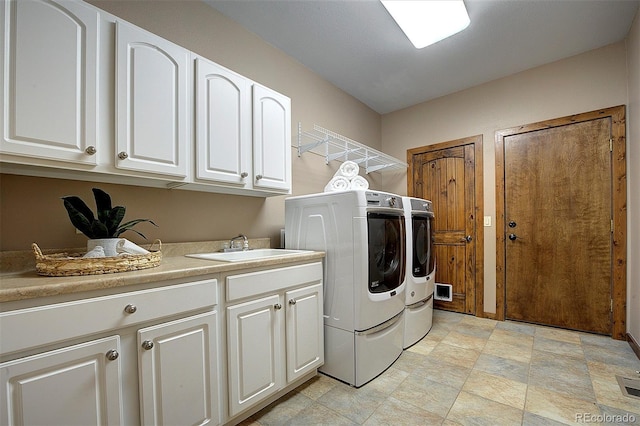 washroom with washer and clothes dryer, cabinet space, and a sink