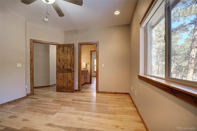 interior space with light wood finished floors, baseboards, and ceiling fan