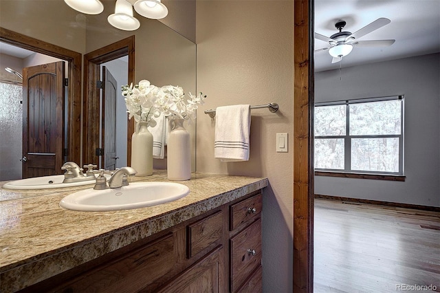 bathroom with vanity, wood finished floors, baseboards, and ceiling fan