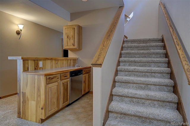 stairs featuring tile patterned floors, bar area, and baseboards