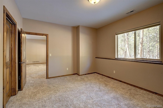 spare room featuring visible vents, baseboards, and carpet