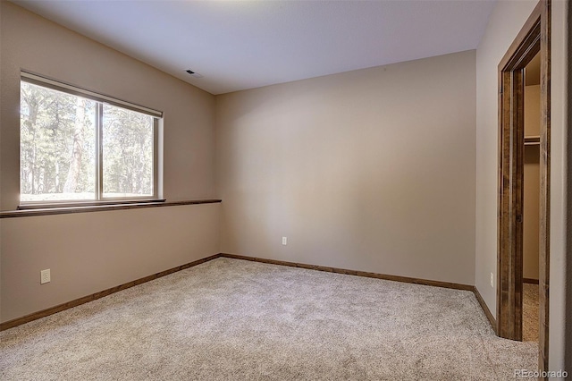 carpeted empty room featuring visible vents and baseboards