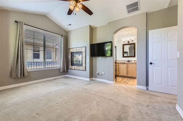 10127 Bluffmont Ln, Lone Tree, CO 80124 - unfurnished bedroom with light colored carpet, vaulted ceiling, arched walkways, ceiling fan, and connected bathroom