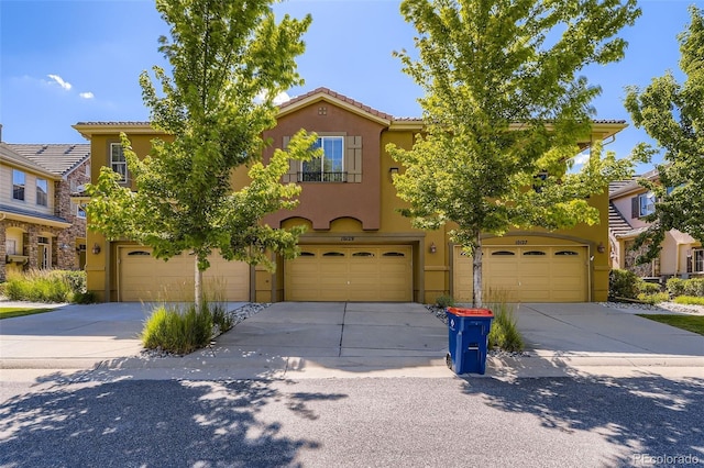 10127 Bluffmont Ln, Lone Tree, CO 80124 - view of front of home featuring stucco siding, a garage, driveway, and a tiled roof