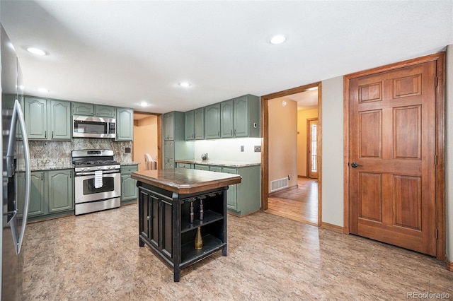 44 Conestoga Ct, Bailey, CO 80421 - kitchen featuring stainless steel appliances, green cabinetry, tasteful backsplash, a kitchen island, and recessed lighting