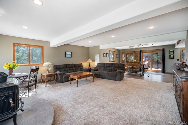 44 Conestoga Ct, Bailey, CO 80421 - living area with carpet floors, recessed lighting, a wood stove, beamed ceiling, and baseboards