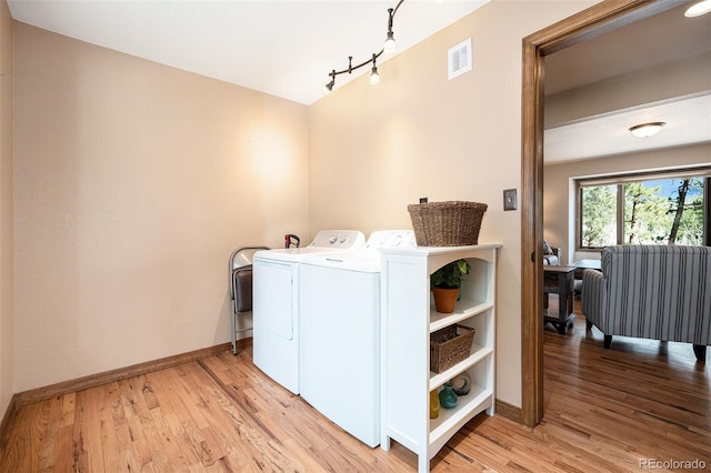 44 Conestoga Ct, Bailey, CO 80421 - laundry area featuring baseboards, light wood finished floors, washer and clothes dryer, and rail lighting