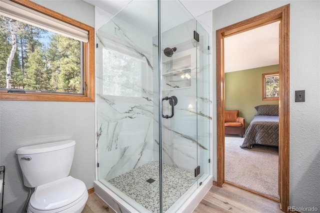 44 Conestoga Ct, Bailey, CO 80421 - full bathroom featuring a marble finish shower, connected bathroom, toilet, wood finished floors, and a textured wall