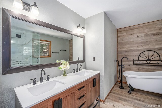 44 Conestoga Ct, Bailey, CO 80421 - full bathroom featuring wooden walls, a marble finish shower, double vanity, a soaking tub, and wood finished floors
