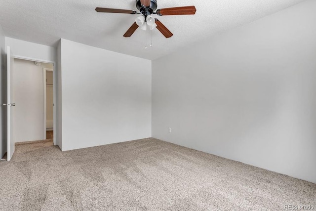 carpeted spare room featuring ceiling fan and a textured ceiling